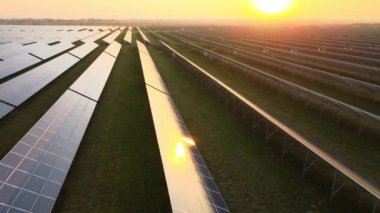 Akşamları temiz elektrik enerjisi üretmek için sıra sıra güneş fotovoltaik panelleri olan sürdürülebilir büyük elektrik santralinin havadan görünüşü. Sıfır emisyonlu yenilenebilir elektrik kavramı