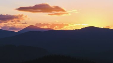 Güzel bir akşam panoramik manzarası. Gün batımında uzak dağ tepeleri üzerinde parlak batan güneş.