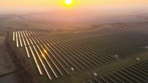 Widok z lotu ptaka na dużą zrównoważoną elektrownię z wieloma rzędami słonecznych paneli fotowoltaicznych do produkcji czystej energii elektrycznej o zachodzie słońca. Odnawialna energia elektryczna z koncepcją zerowej emisji — Wideo stockowe