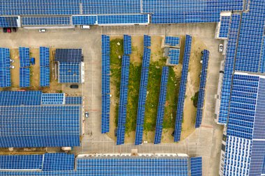 Mavi fotovoltaik güneş panelleri temiz ekolojik elektrik üretmek için endüstriyel binaların çatısına monte edildi. Yenilenebilir enerji konsepti üretimi