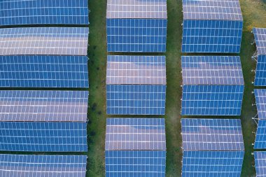 Temiz ekolojik elektrik enerjisi üretmek için sıra sıra güneş fotovoltaik panelleri olan sürdürülebilir büyük elektrik santralinin havadan görünüşü. Sıfır emisyon kavramı ile yenilenebilir elektrik.