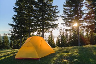 Parlak güneşli bir akşamda dağ kamp alanında turist kampı çadırı. Aktif turizm ve yürüyüş konsepti