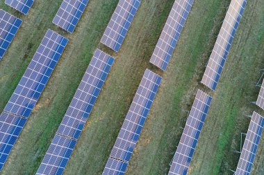Temiz ekolojik elektrik enerjisi üretmek için sıra sıra güneş fotovoltaik panelleri olan sürdürülebilir büyük elektrik santralinin havadan görünüşü. Sıfır emisyon kavramı ile yenilenebilir elektrik