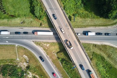 Şehir caddelerinde yoğun trafik varken kavşağın hava görüntüsü. Çok sayıda araç ve kamyonla yoğun saatlerde şehir ulaşımı