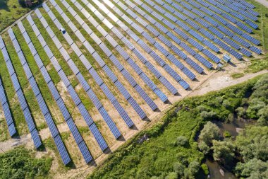 Yeşil alandaki güneş enerjisi santralinin havadan görüntüsü. Temiz ekolojik enerji üretmek için panelleri olan elektrik çiftliği
