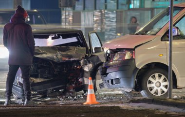 Şehir caddesinde gece çarpışma ve siluet halindeki insanların çarpışması sonucu arabalar ağır bir şekilde kaza yaptı. Yol güvenliği ve sigorta kavramı