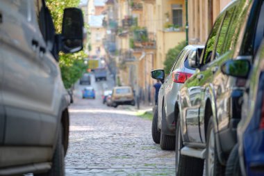 Sokak kenarında park halindeki arabalarla şehir trafiği