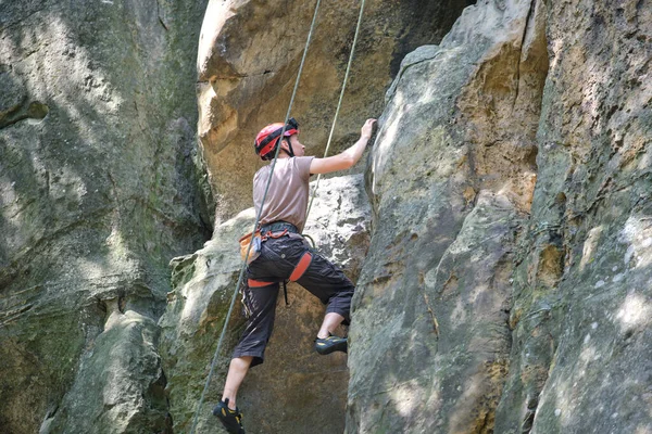 Fort grimpeur mâle escalade mur escarpé de montagne rocheuse. Sportif surmonter la route difficile. Se livrer à des sports extrêmes concept de passe-temps — Photo