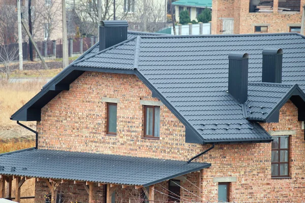 Evin çatısındaki baca inşaat halindeki metalik kiremitlerle kaplı. Binayı kaplayan fayanslar. Gayrimenkul geliştirme — Stok fotoğraf