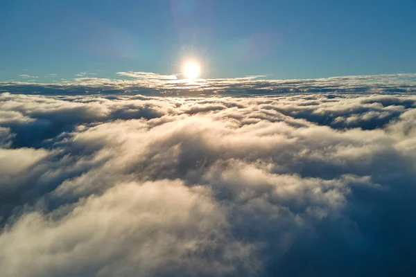 Luftaufnahme von oben in großer Höhe mit dichten, geschwollenen Kumuluswolken, die am Abend fliegen. Erstaunlicher Sonnenuntergang aus Sicht des Flugzeugfensters — Stockfoto