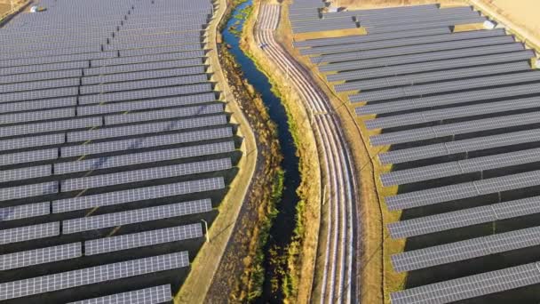 Vista aerea di grande centrale elettrica sostenibile con filari di pannelli fotovoltaici solari per la produzione di energia elettrica ecologica pulita. Elettricità rinnovabile a emissioni zero — Video Stock