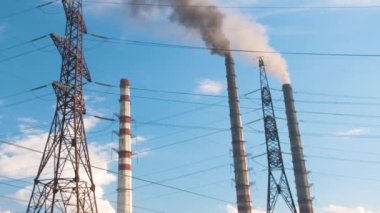 Kömür santraline karşı yüksek voltajlı elektrik direkleri siyah dumanlı yüksek borular atmosferi kirletiyor. Fosil yakıt kavramına sahip elektrik enerjisi üretimi