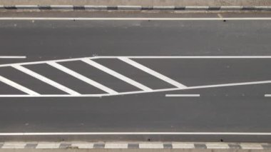 Beyaz işaretli ve hızlı sürüş arabalı şehir caddesinin havadan görünüşü. Şehir trafiğinin insansız hava aracının üst görüntüsü