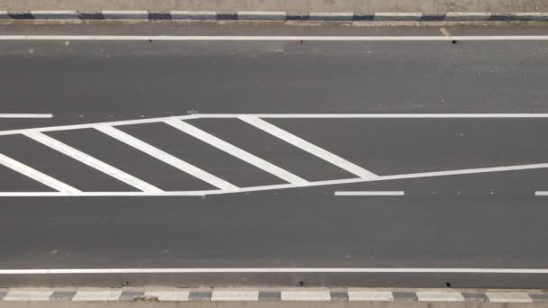 Luchtfoto van de stad straat met witte markeringen en snelrijdende auto 's. Top uitzicht van drone van het stedelijk verkeer — Stockvideo