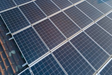Temiz ekolojik elektrik enerjisi üretmek için sıralanmış mavi güneş fotovoltaik panelleri olan hava manzaralı çatı. Sıfır emisyon kavramı ile yenilenebilir elektrik