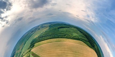 Küçük gezegenimizin yüksek irtifasından, sarı ekili tarım tarlaları, olgunlaşmış buğday ve yeşil ormanlarla aydınlık yaz gününde.