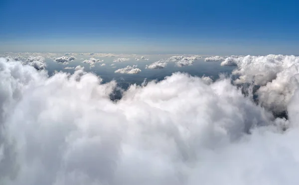 Dünya 'nın yüksek irtifasındaki uçak penceresinden hava manzarası beyaz kabarık kümülüs bulutlarıyla kaplı. — Stok fotoğraf