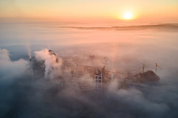 Vista aérea de la fábrica de cemento con estructura de planta de hormigón alto y grúa torre en el sitio de producción industrial en la mañana brumosa. Fabricación y concepto de industria global —  Fotos de Stock