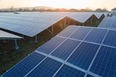 Temiz ekolojik elektrik enerjisi üretmek için sıra sıra güneş fotovoltaik panelleri olan sürdürülebilir büyük elektrik santralinin havadan görünüşü. Sıfır emisyon kavramı ile yenilenebilir elektrik.