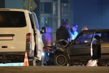 Şehir caddesinde gece çarpışma ve siluet halindeki insanların çarpışması sonucu arabalar ağır bir şekilde kaza yaptı. Yol güvenliği ve sigorta kavramı