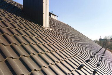 Kışın güvenlik için çatıdaki çelik kiremitlerle kaplı kar muhafızı. Binanın döşeme kaplaması