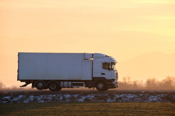 Camión de carga conduciendo en la carretera transportando mercancías por la noche. Transporte de entrega y concepto logístico — Foto de Stock