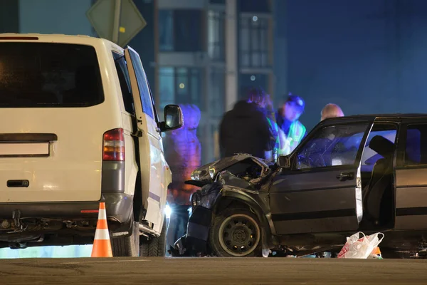 Samochody mocno rozbiły się w wypadku drogowym po zderzeniu i sylwetce ludzi na ulicy miejskiej w nocy. Koncepcja bezpieczeństwa ruchu drogowego i ubezpieczenia — Zdjęcie stockowe