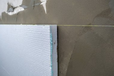 Termal koruma için ev cephesi duvarına köpük yalıtım çarşafları kurulumu