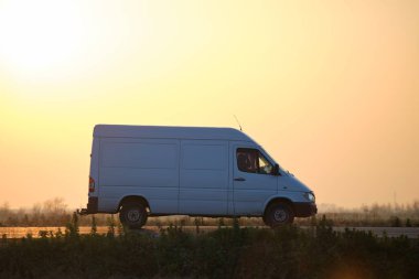 Otobanda mal taşıyan küçük bir kargo minibüsü. Teslimat ulaşım ve lojistik kavramı