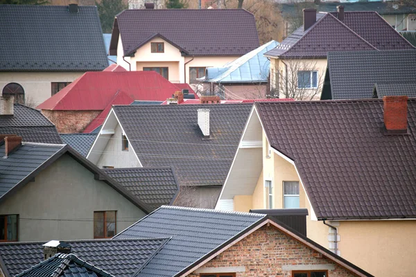 Case residenziali con tetti ricoperti di tegole metalliche e ceramiche in zona suburbana rurale — Foto Stock