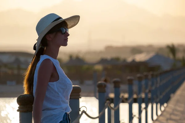 Giovane turista donna in abiti casual godendo di calda serata di sole sulla riva del mare. Vacanze estive e concetto di viaggio — Foto Stock