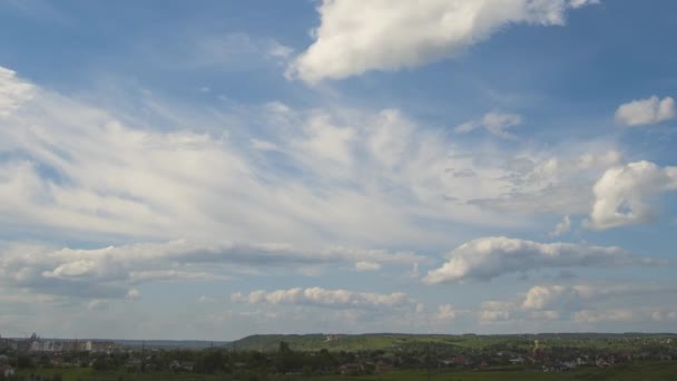 Запись быстрого движения белых пушистых облаков на голубом небе над сельской местностью — стоковое видео