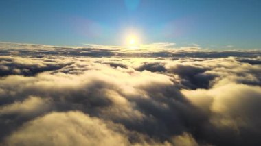 Yükseklerdeki uçak penceresinden akşam uçuşan yoğun kabarık kümülüs bulutlarının hava görüntüsü