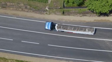 Beyaz işaretli ve hızlı sürüş arabalı şehir caddesinin havadan görünüşü. Şehir trafiğinin insansız hava aracının üst görüntüsü