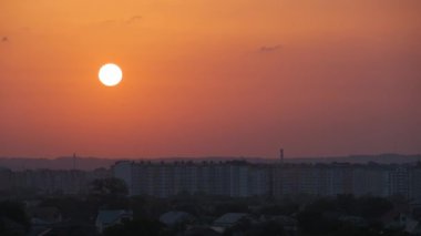 Güneş batarken akşam manzarası Uzak şehrin yüksek binalarının üzerinde gün batımında