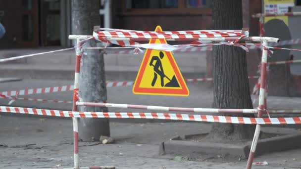 Panneau d'avertissement des travaux routiers et barrière de sécurité sur la rue de la ville pendant les travaux d'entretien — Video