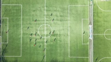 Yeşil spor stadyumunda futbol oynayan futbolcuların hava manzarası