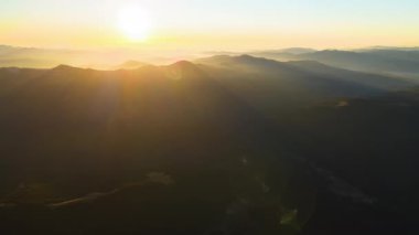 Gün batımında puslu tepeleri ve sisli vadisi olan güzel dağ panoramik manzarası