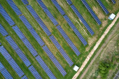 Temiz ekolojik elektrik enerjisi üretmek için birçok sıra güneş fotovoltaik paneli bulunan sürdürülebilir büyük elektrik santralinin havadan görünüşü. Sıfır emisyon kavramı ile yenilenebilir elektrik