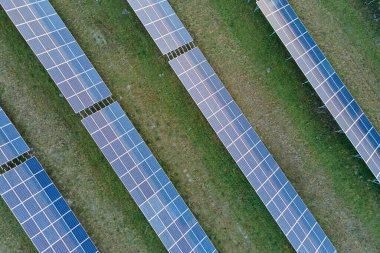 Temiz ekolojik elektrik enerjisi üretmek için sıra sıra güneş fotovoltaik panelleri olan sürdürülebilir büyük elektrik santralinin havadan görünüşü. Sıfır emisyon kavramı ile yenilenebilir elektrik