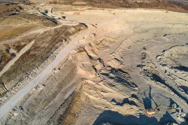Vista aérea do local de mineração a céu aberto de materiais de pedra calcária para a indústria da construção com escavadeiras e caminhões basculantes — Fotografia de Stock