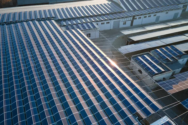 Vista aérea de la planta de energía solar con paneles fotovoltaicos azules montados en el techo del edificio industrial para producir electricidad ecológica verde. Producción del concepto de energía sostenible — Foto de Stock