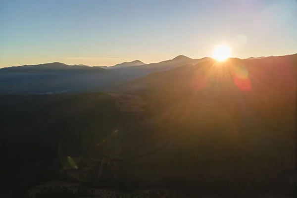 Schöne Berglandschaft mit nebligen Gipfeln und nebligem Tal bei Sonnenuntergang — Stockfoto