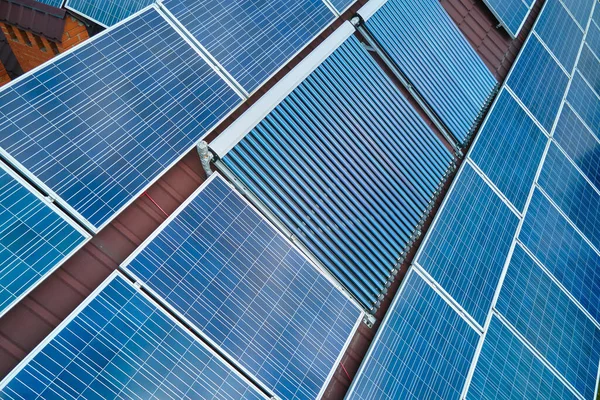Su ısıtmak ve temiz ekolojik elektrik üretmek için mavi fotovoltaik paneller ve vakumlu güneş enerjisi toplayıcılarıyla çatı inşa ediyorlar. Sıfır emisyonlu yenilenebilir elektrik ve ısı enerjisi — Stok fotoğraf