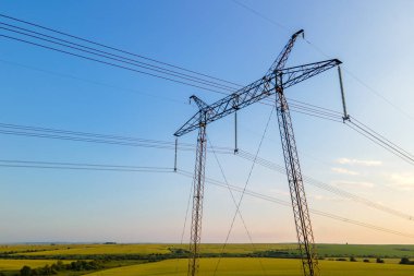 Güneş doğarken elektrik hatları olan yüksek voltajlı kulelerin koyu gölgesi.