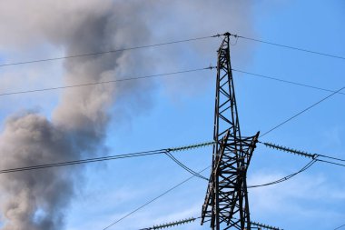 Kömür santraline karşı yüksek voltajlı elektrik direkleri siyah dumanlı yüksek borular atmosferi kirletiyor. Fosil yakıt kavramına sahip elektrik enerjisi üretimi