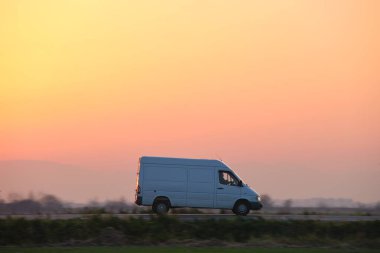 Otobanda mal taşıyan küçük bir kargo minibüsü. Teslimat ulaşım ve lojistik kavramı