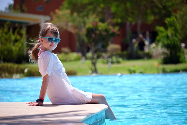 Menina feliz em vestido branco relaxante no lado da piscina no dia ensolarado de verão — Fotografia de Stock