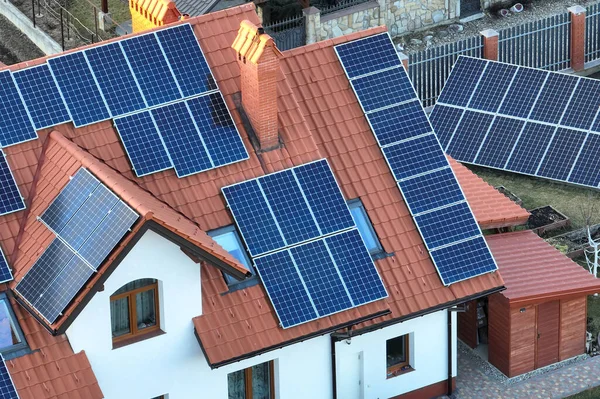 Şehrin kırsal kesimlerinde temiz ekolojik elektrik enerjisi üretmek için güneş fotovoltaik panellerle kaplı özel bir çatı. Özerk ev kavramı — Stok fotoğraf
