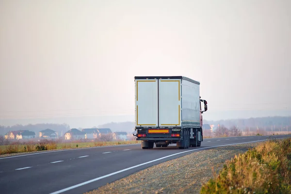 Semi-vrachtwagen met lading aanhangwagen rijden op de snelweg vervoeren goederen in de avond. Levering transport en logistiek concept — Stockfoto